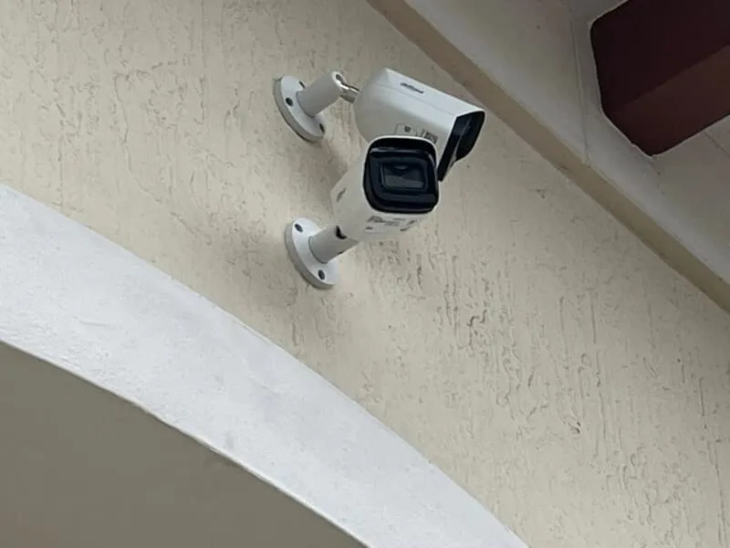 Two security cameras pointed in different directions attached to wall on an establishment in Port St. Lucie, FL